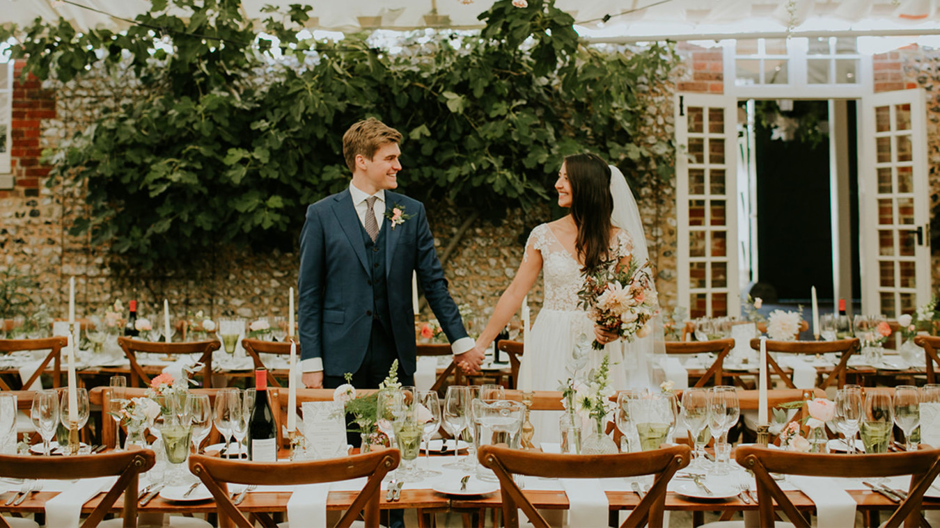 Bignor Park Weddings couple in The Stable courtyard amongst reception tables