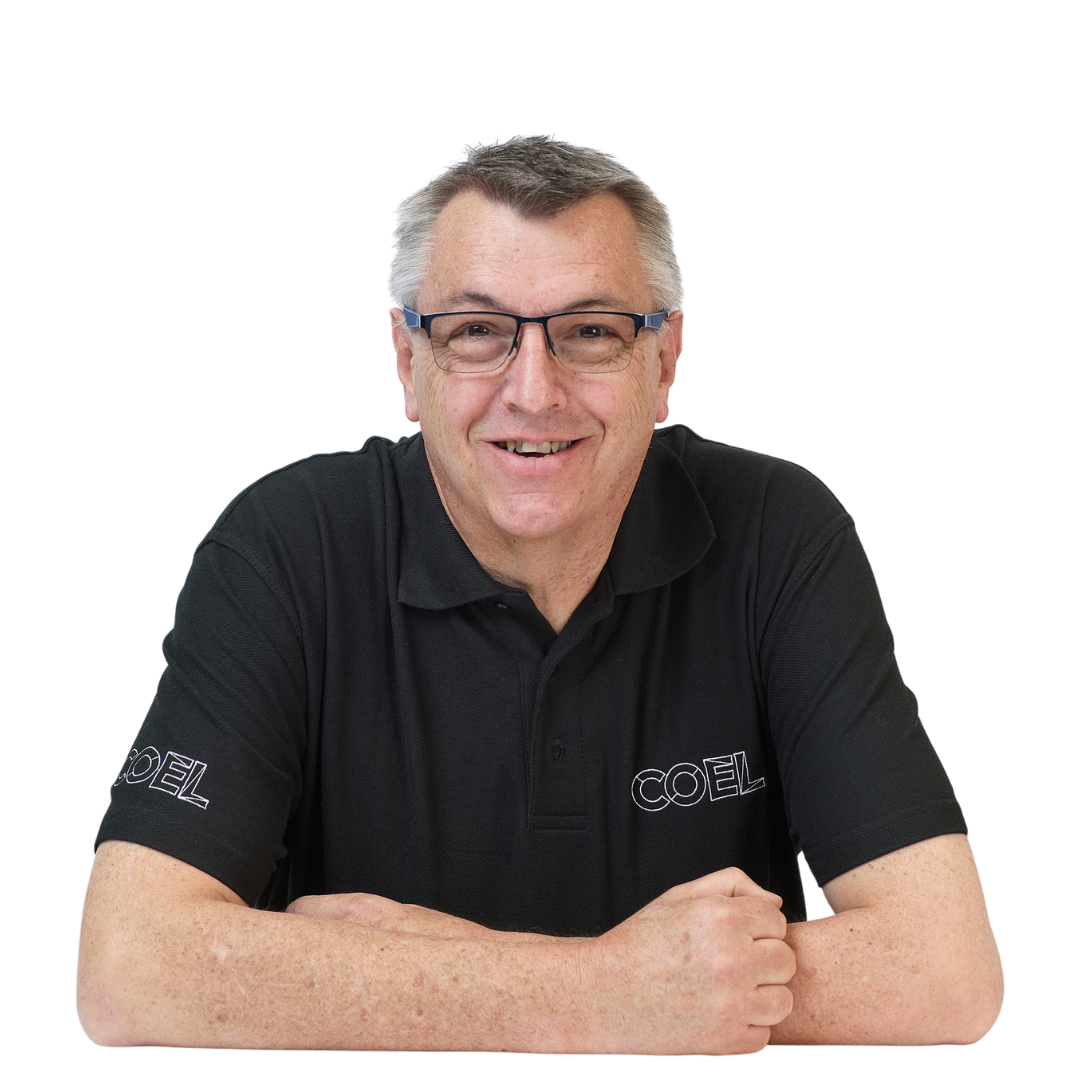 A person wearing glasses and a black polo shirt with "COEL" embroidered is smiling while seated against a white background.