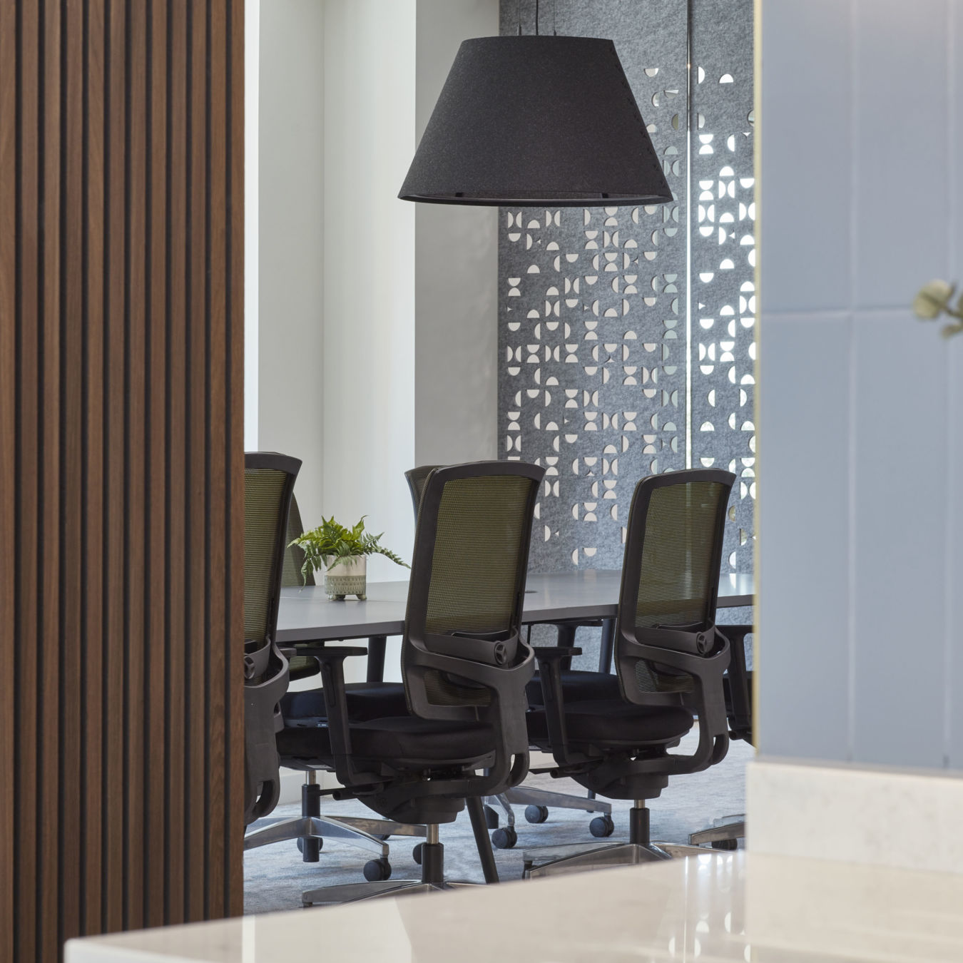 Stylish office interior with ergonomic chairs, decorative partition, and modern lighting, part of COEL’s workspace design for Mishcon De Reya.