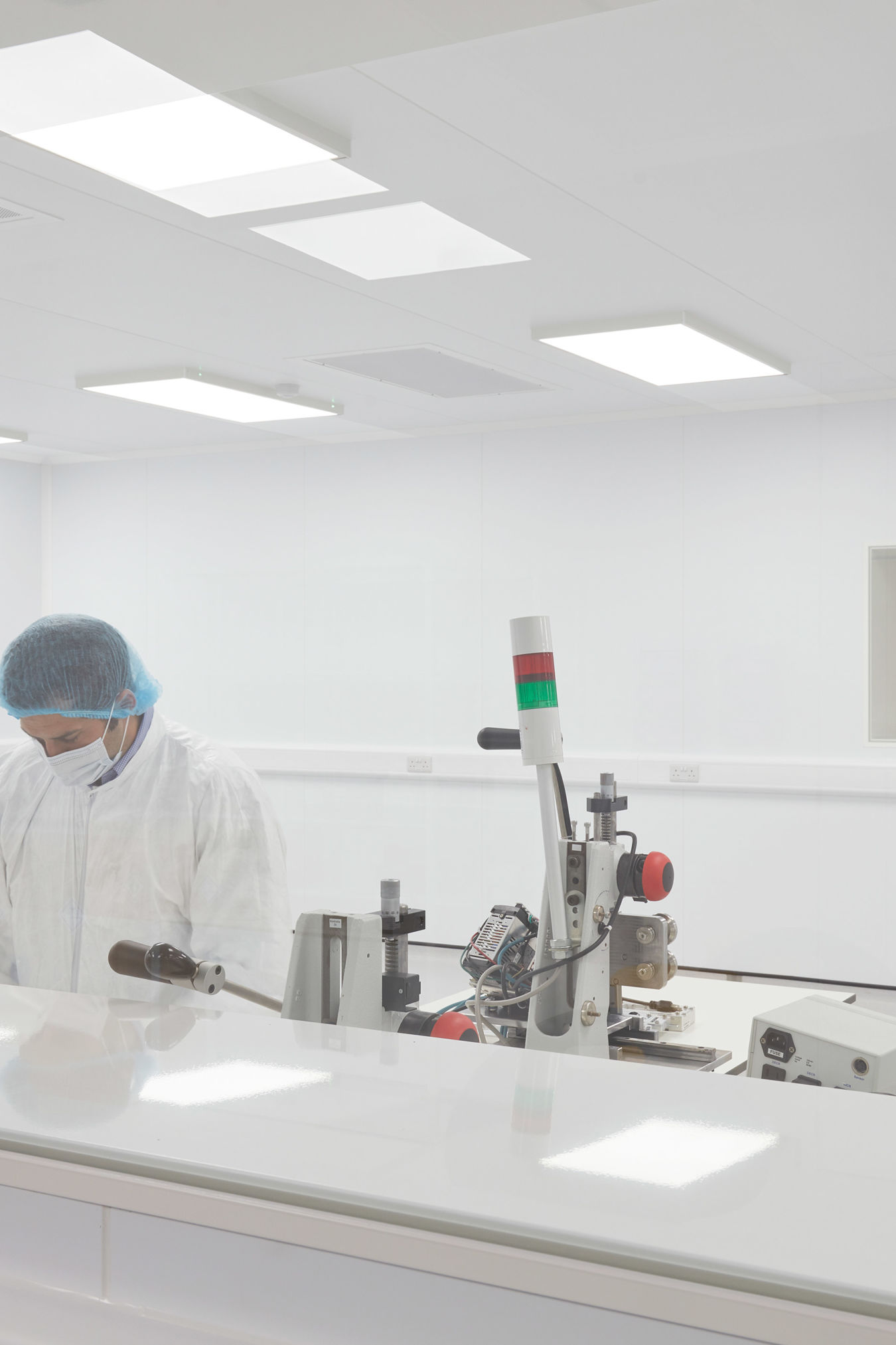 Laboratory technician working in a cleanroom environment with sterile white surfaces and equipment, part of a COEL Lab Planning project for Sense Bio.