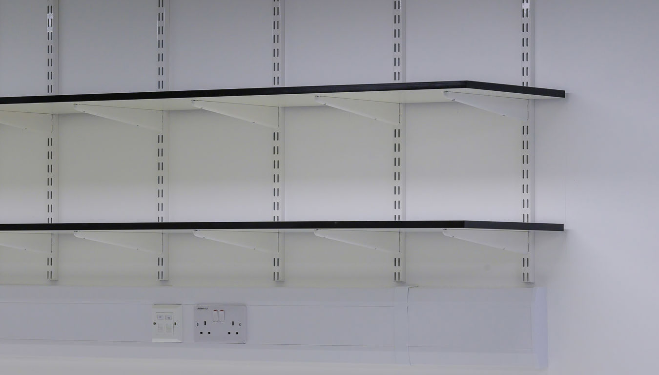 Close-up of laboratory wall shelving with integrated power outlets, designed for flexible storage in a COEL lab planning project.