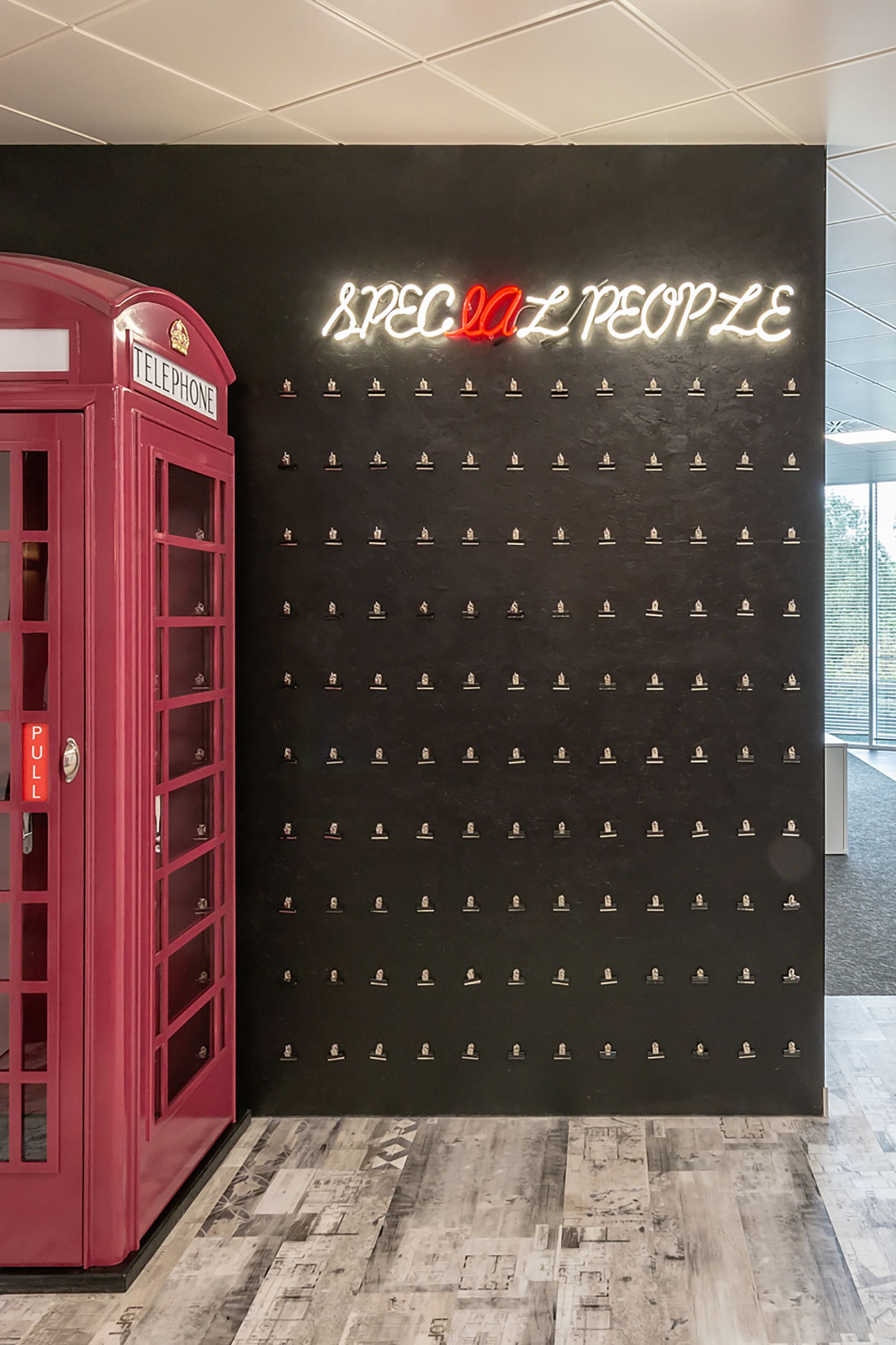 Office hallway featuring a red British-style phone booth repurposed as a private call space, part of a COEL fit-out for Stobbs.