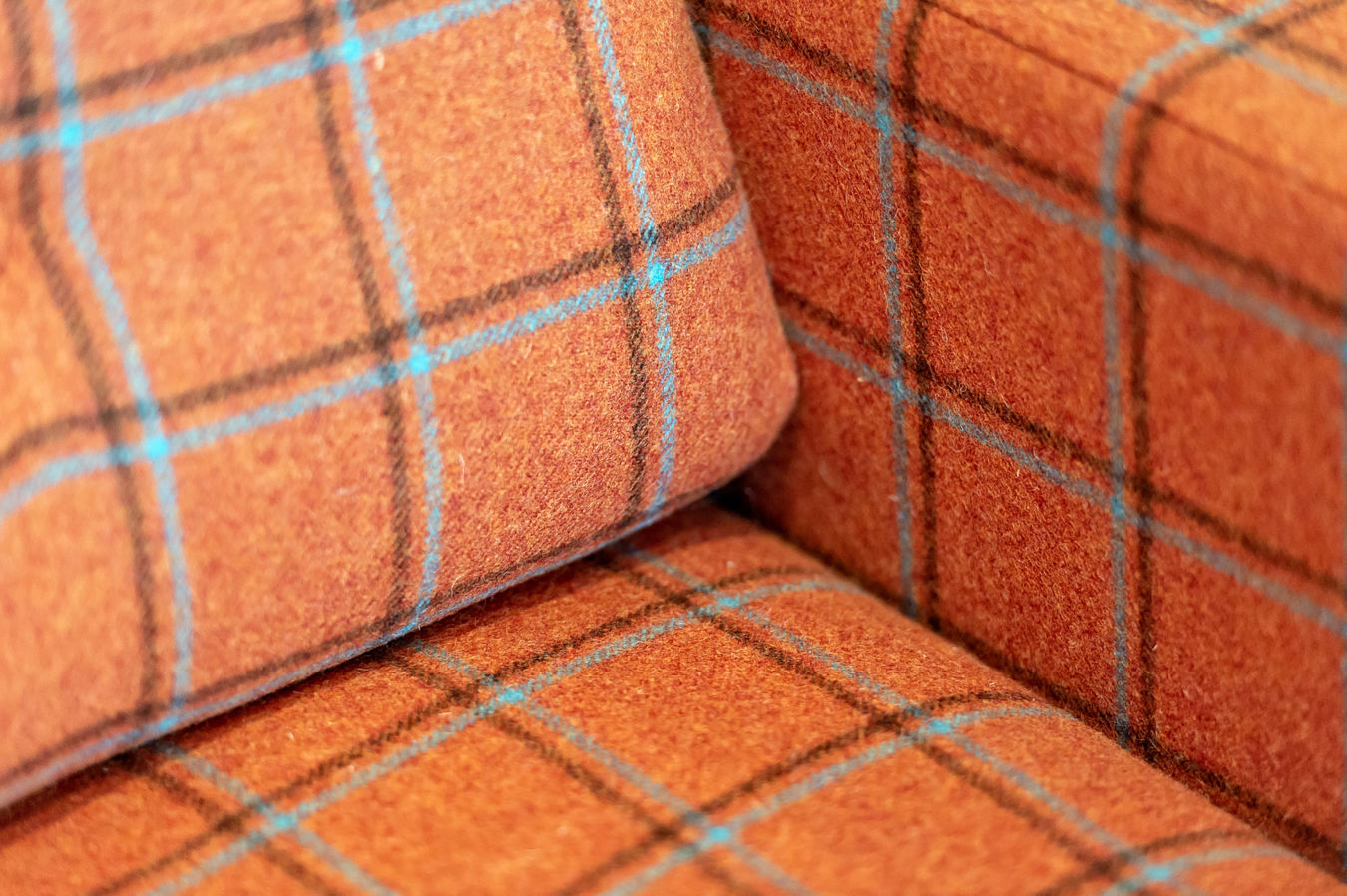 Close-up of orange plaid upholstered sofa fabric, featured in a COEL office furniture installation for Birketts in Ipswich.
