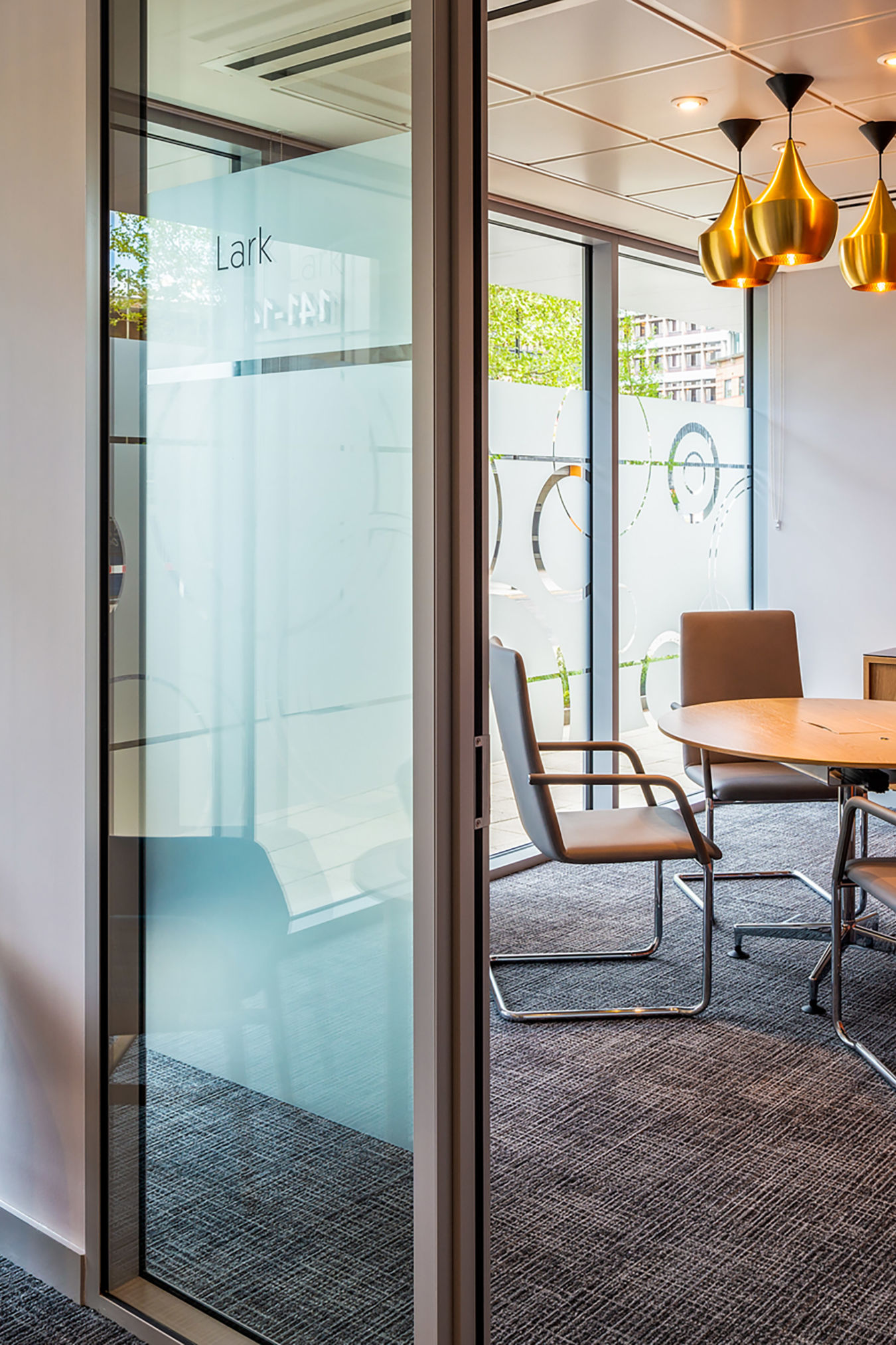 Glass-partitioned meeting room with modern furnishings and pendant lighting, part of COEL’s office fit-out for Birketts in Ipswich.