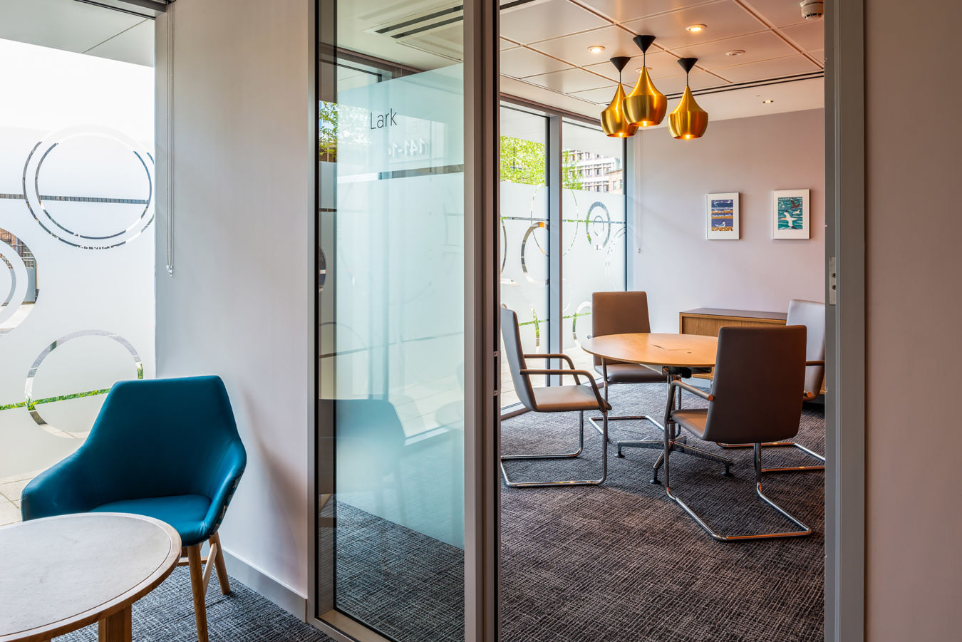 Glass-partitioned meeting room with modern furnishings and pendant lighting, part of COEL’s office fit-out for Birketts in Ipswich.
