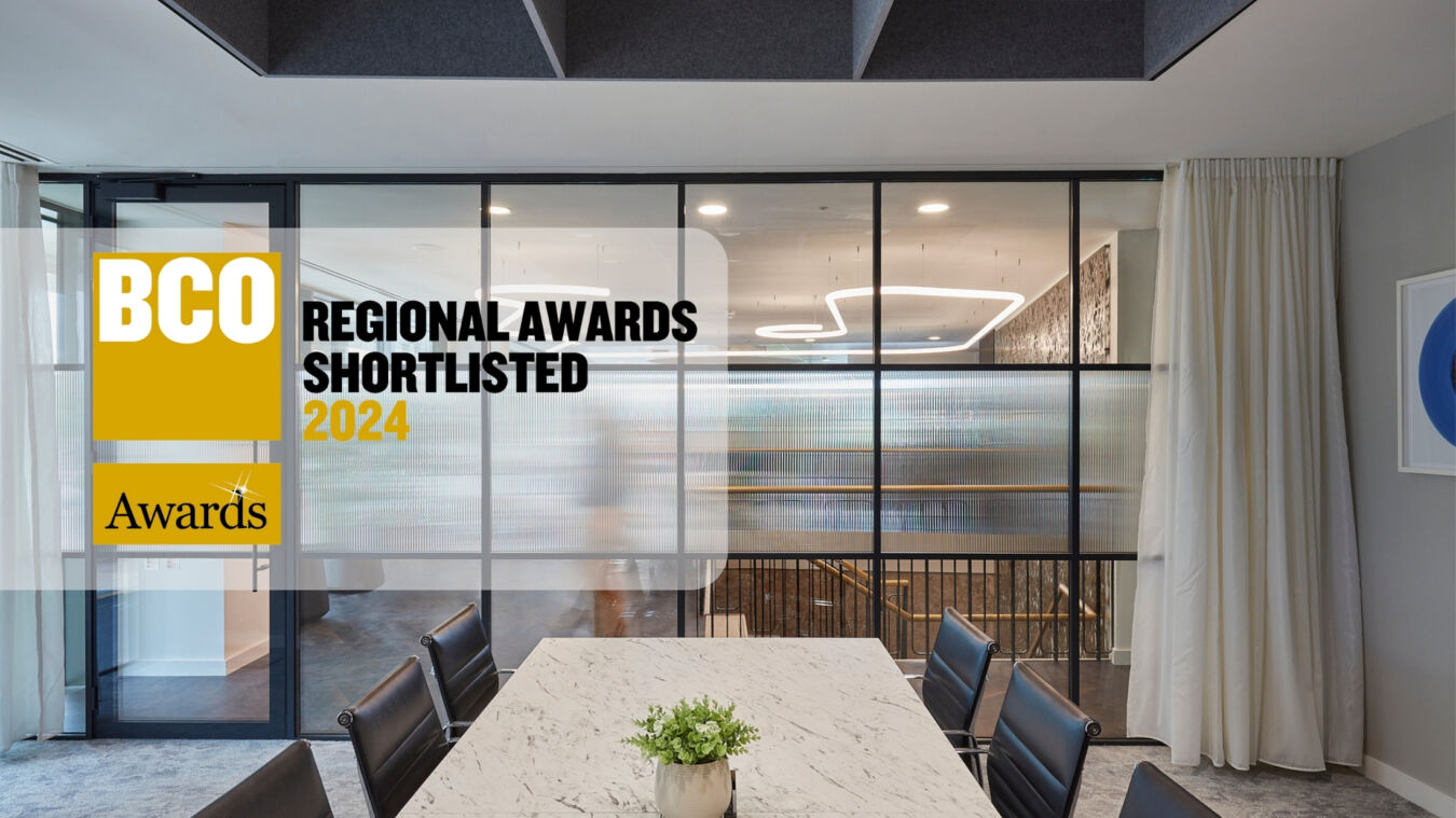 A modern conference room with a marble table and black chairs is featured, set against a glass partition. Text reads “BCO Regional Awards Shortlisted 2024” and “Awards.”