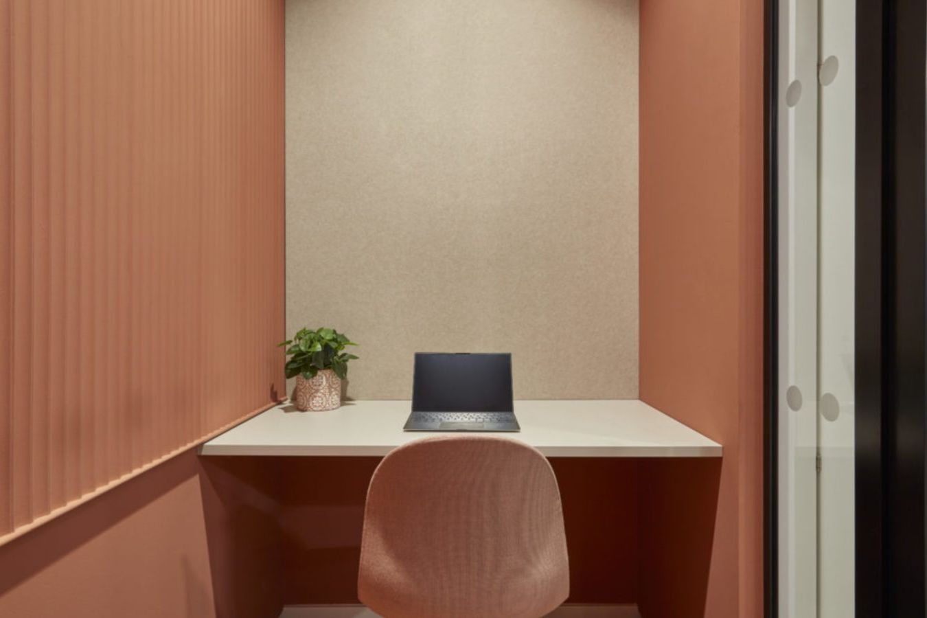 small office nook with a desk, chair, and a plant